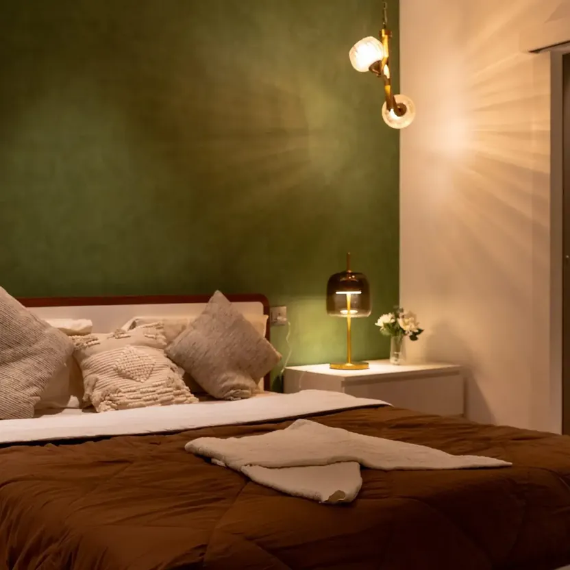Elegance by Guru Punvaanii, Bidadi, show villa A bedroom with a green feature wall, cushions and bedside lamps in the Elegance show villa
